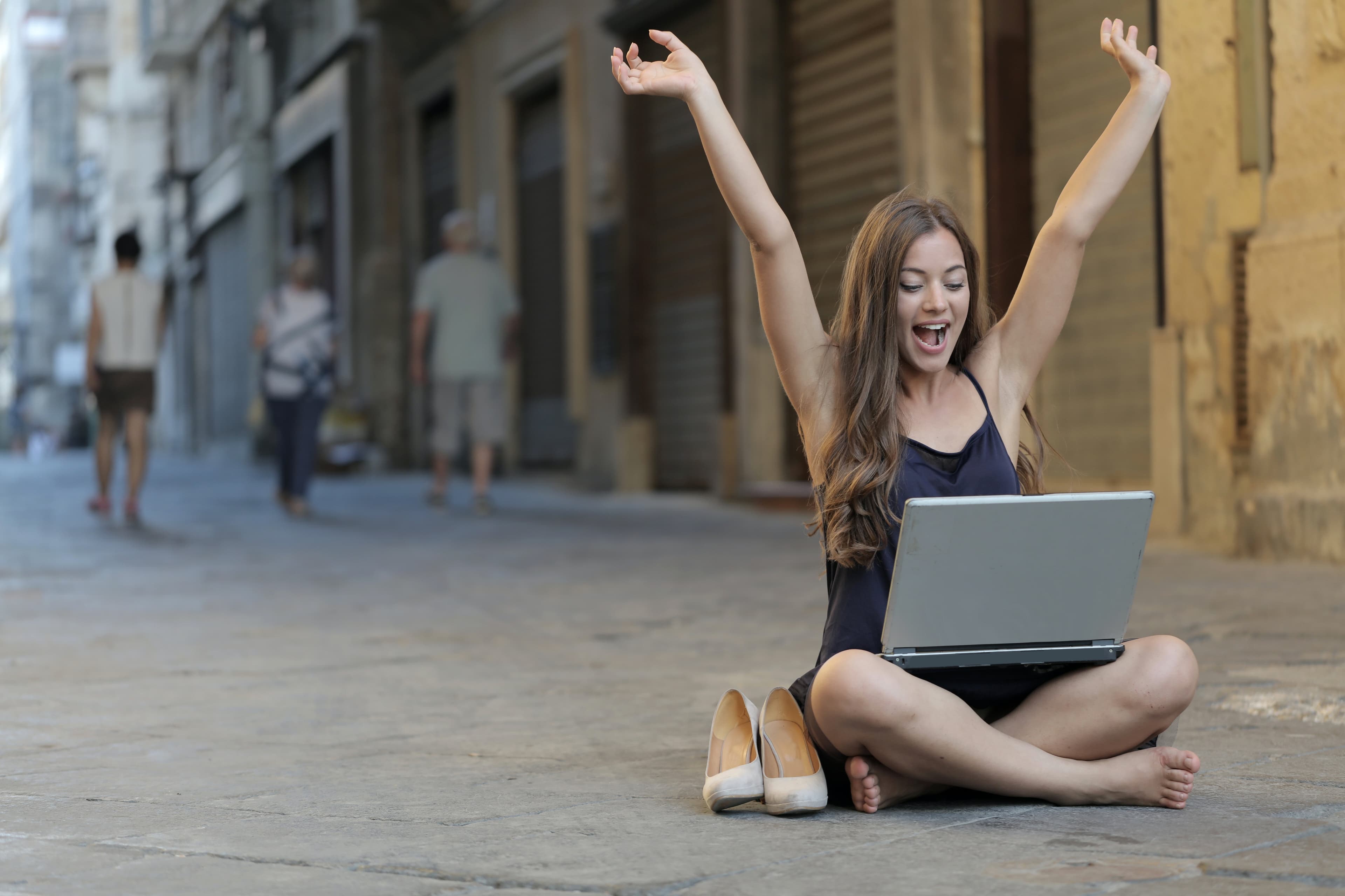 Women sitting on concrete - hands in the air